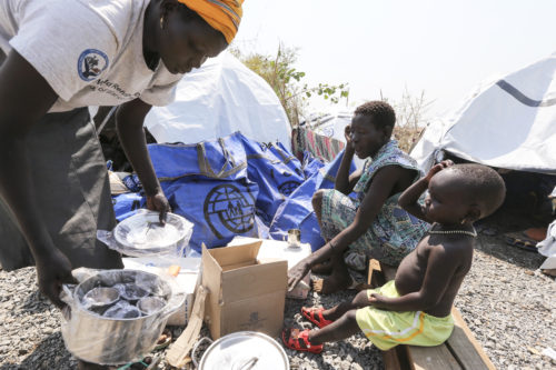 After receiving Humanitarian aid, she arrived into her tent, she and her family members looking at items received on January 6, 2014 from IOM.
